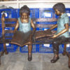 Bronze kids reading on a bench