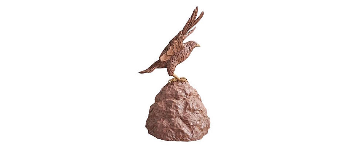 Completed clay sculpture of a peregrine falcon perched on a sculpted rock base with wings spread, prepared for mold making and bronze casting.