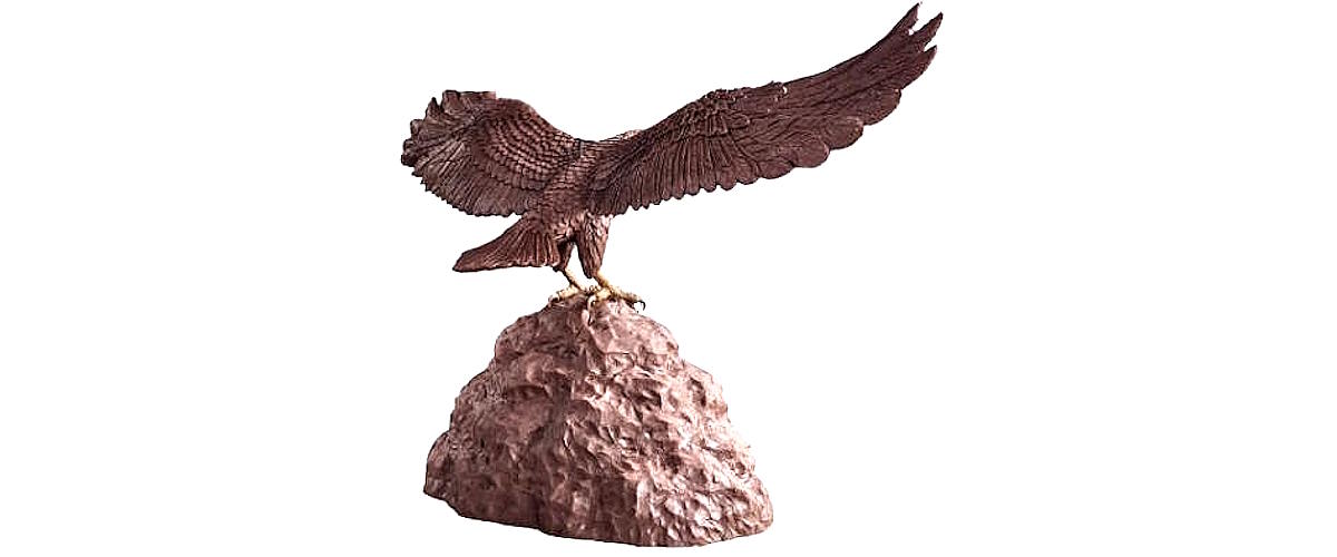 Side view of a completed clay peregrine falcon sculpture perched on a rock base with wings fully extended before mold making and bronze casting.