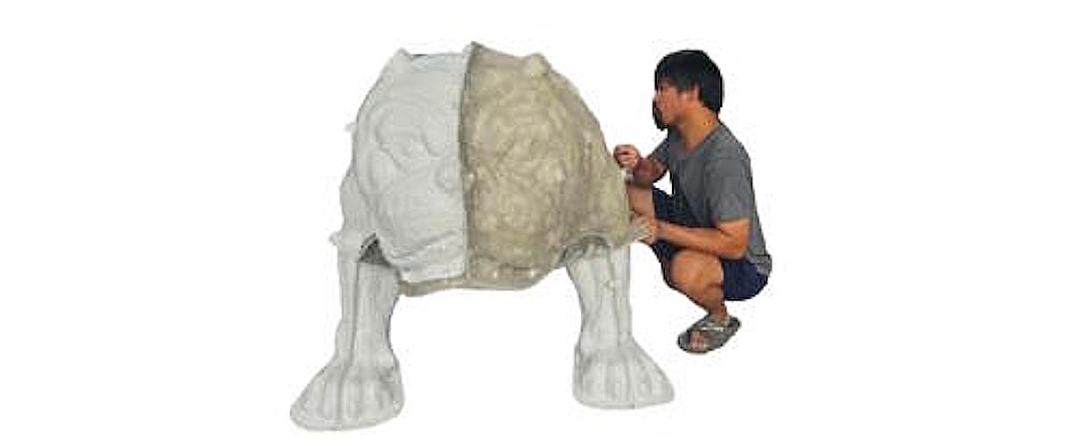 Artist refining the clay body of the Tracy High School bulldog mascot sculpture