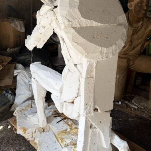 Front view of the Spartan Brigade monument during the early development stage, showing the sculpture divided into foam sections as it is prepared for the bronze casting process.