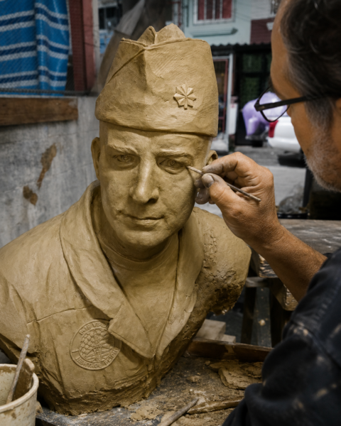 Sculptor refining the clay likeness of Lt. Col. Dan Rooney using the 3D printed prototype and digital reference to create a custom bronze tribute for Folds of Honor.